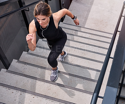 Buy stock photo High angle shot of a sporty young woman running up a staircase outdoors