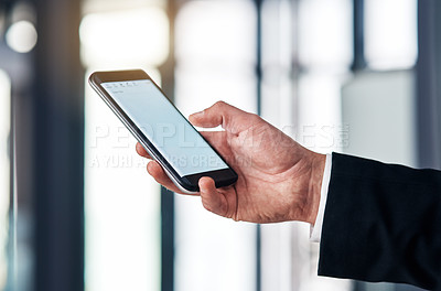 Buy stock photo Cropped shot of an unrecognisable businessmen using a smartphone in a modern office