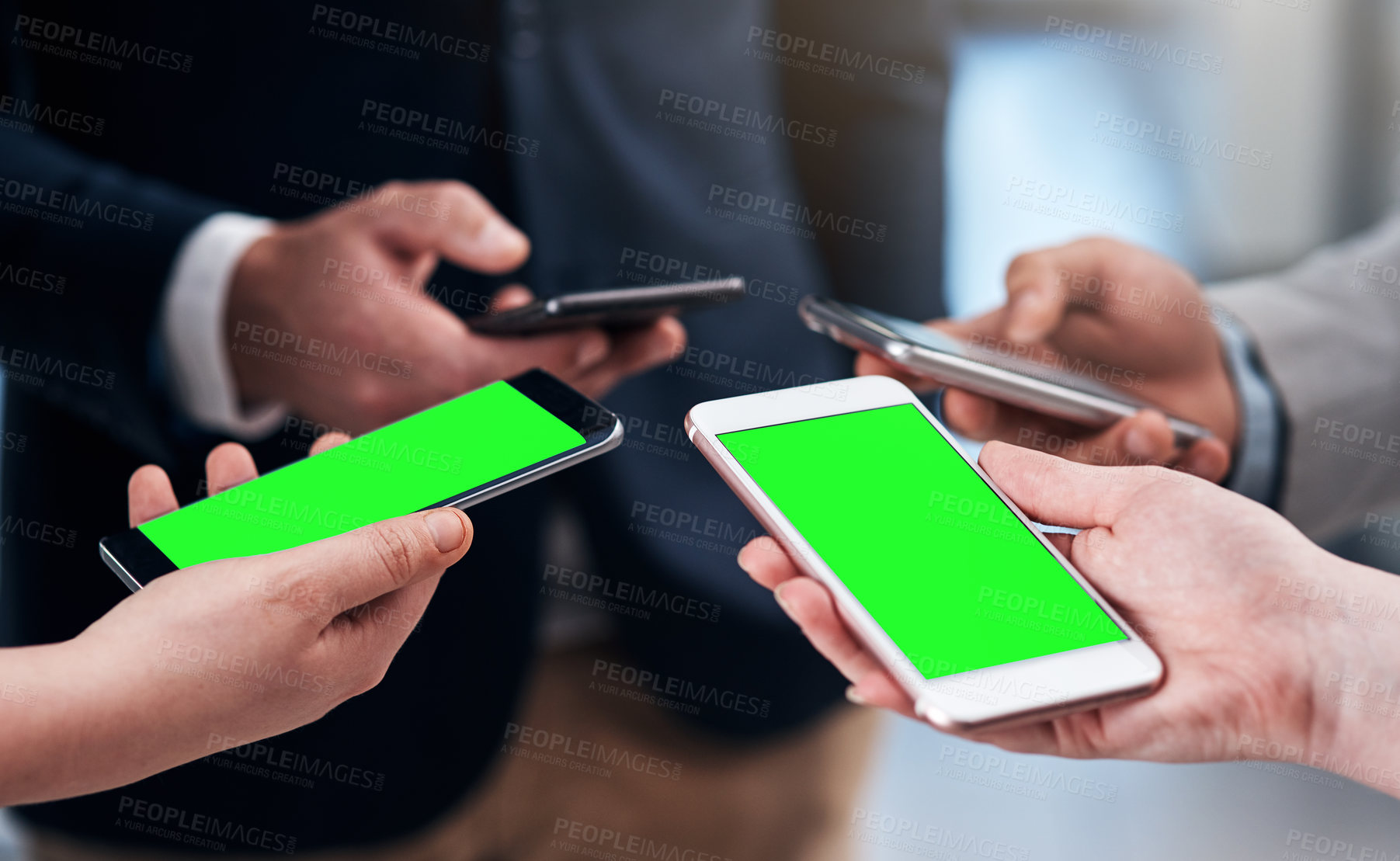 Buy stock photo Cropped shot of a group of businesspeople using their mobile phones during a collaboration