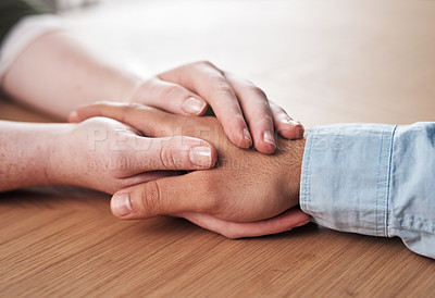 Buy stock photo Love, support and people holding hands on table for marriage, kindness and understanding at home. Couple, trust and connection with compassion in commitment for partnership, forgiveness and comfort