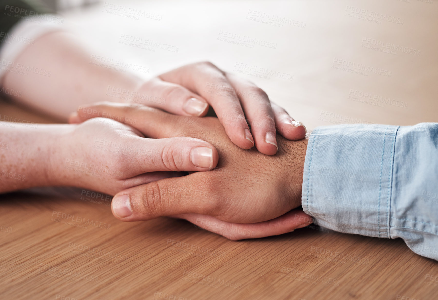 Buy stock photo Love, support and people holding hands on table for marriage, kindness and understanding at home. Couple, trust and connection with compassion in commitment for partnership, forgiveness and comfort