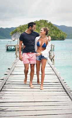 Buy stock photo Happy couple, tropical and ocean boardwalk with walking, hug and outdoor in summer sunshine for holiday. Man, woman and walk together by sea with love, happiness and care with travel for vacation