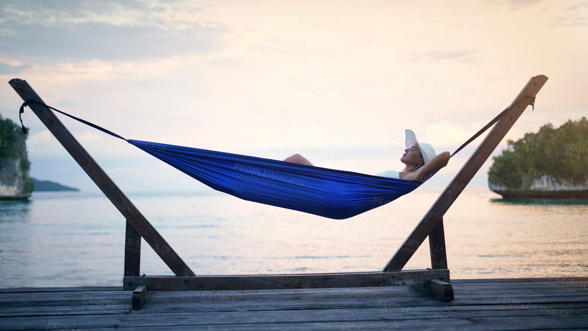 Buy stock photo Hammock, sunset ocean and woman relax outdoor on a vacation, holiday or adventure in nature. Female person on tropical trip, travel and deck with sea, sky and water in summer for zen, peace and calm