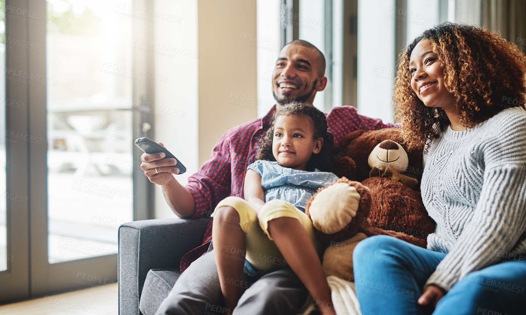 Buy stock photo Love, smile and family on a couch, watching tv and bonding on a weekend break, home or chilling. Happy parents, mother or father with kid, female child or daughter on a sofa, happiness and television