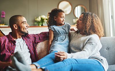 Buy stock photo Cropped shot of an adorable little girl spending time with her parents in their living room at home