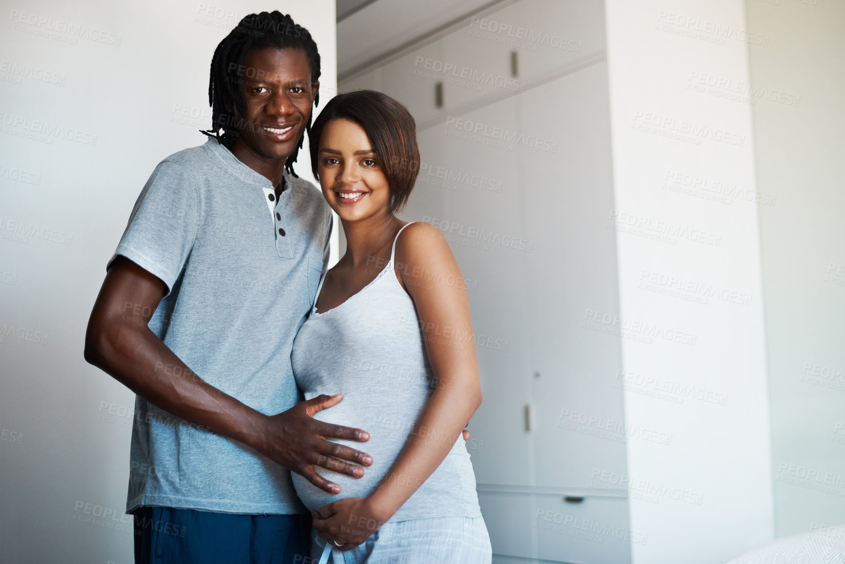 Buy stock photo Happy couple, portrait and pregnancy with belly for maternity or expectation to start a family at home. Young man and pregnant woman with baby bump, hug or love for support or care together at house