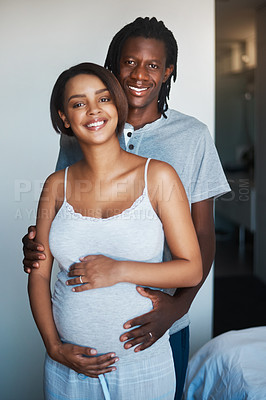 Buy stock photo Portrait of happy young man posing with his pregnant wife at home