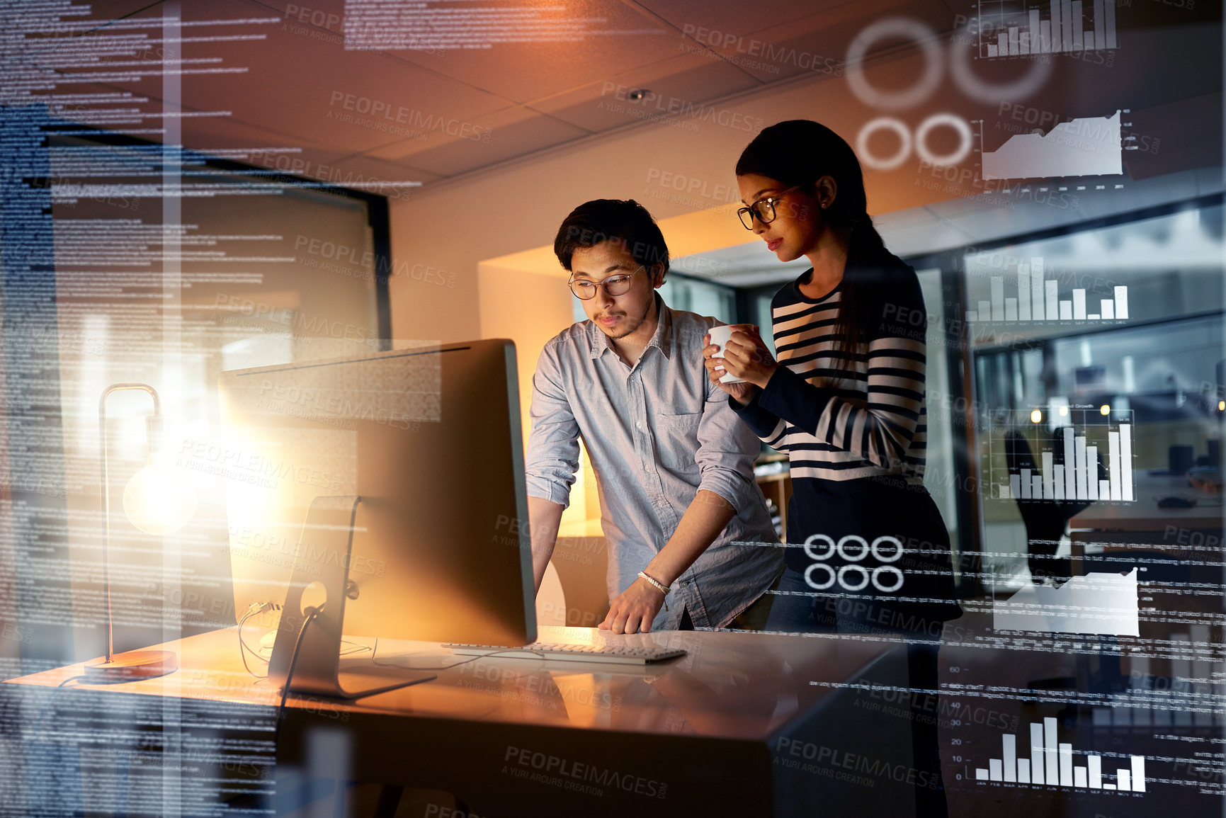 Buy stock photo Shot of colleagues connecting to a user interface while working in an office at night