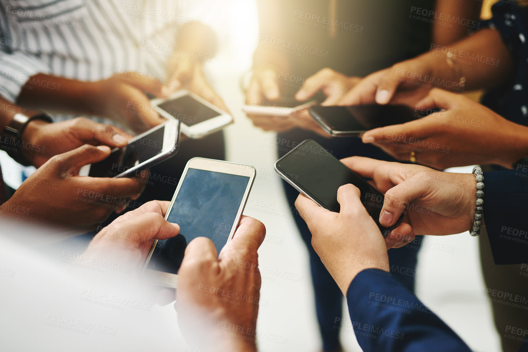 Buy stock photo Closeup shot of a group of unrecognizable businesspeople using their cellphones in synchronicity