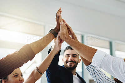 Buy stock photo Cropped shot of a group of businesspeople high fiving in an office