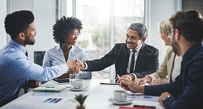 Buy stock photo Cropped shot of a diverse group of businesspeople having a meeting in the office and shaking hands