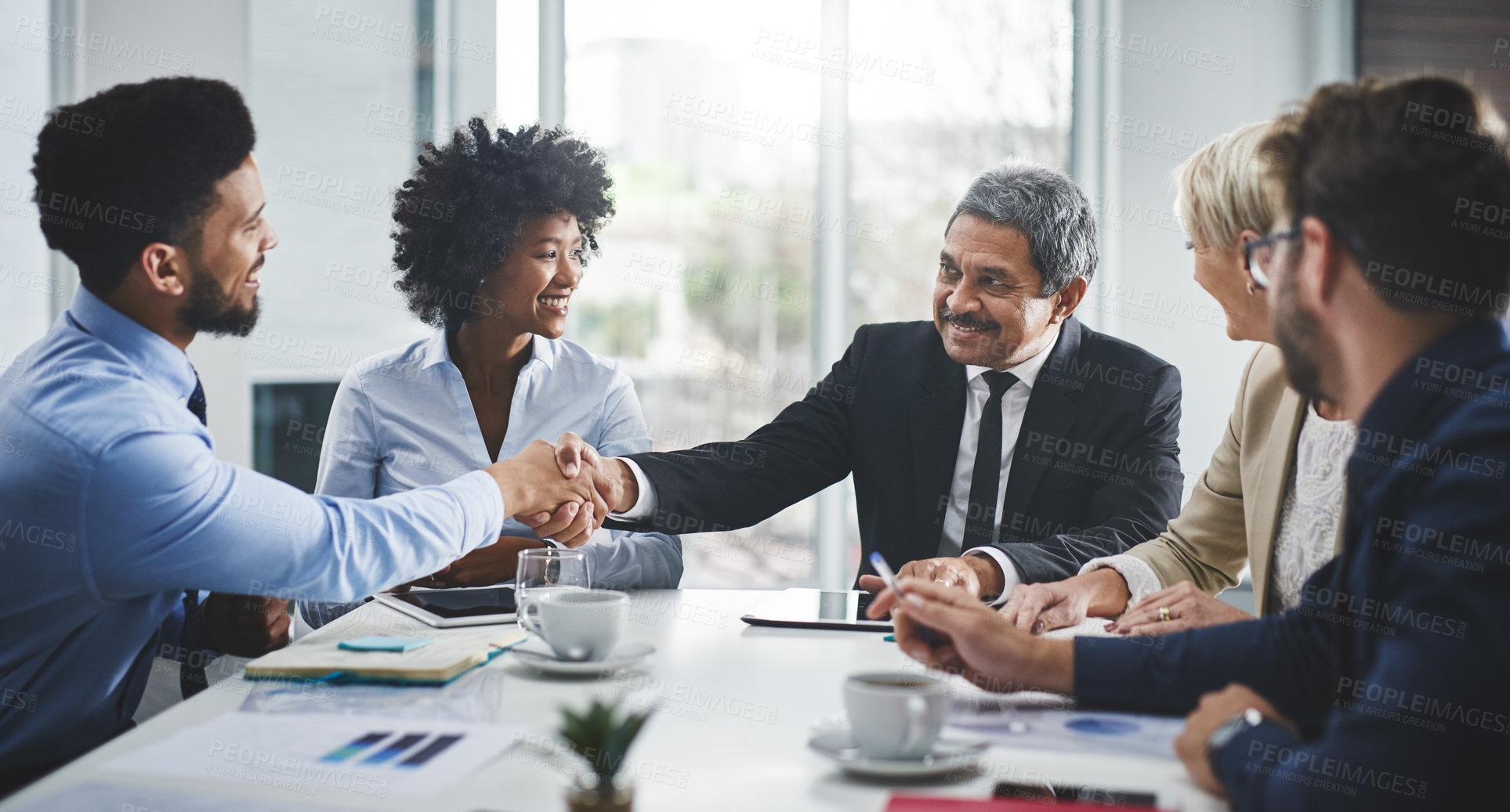 Buy stock photo Cropped shot of a diverse group of businesspeople having a meeting in the office and shaking hands