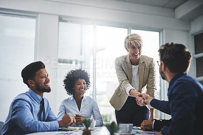 Buy stock photo Cropped shot of a diverse group of businesspeople having a meeting in the office and shaking hands