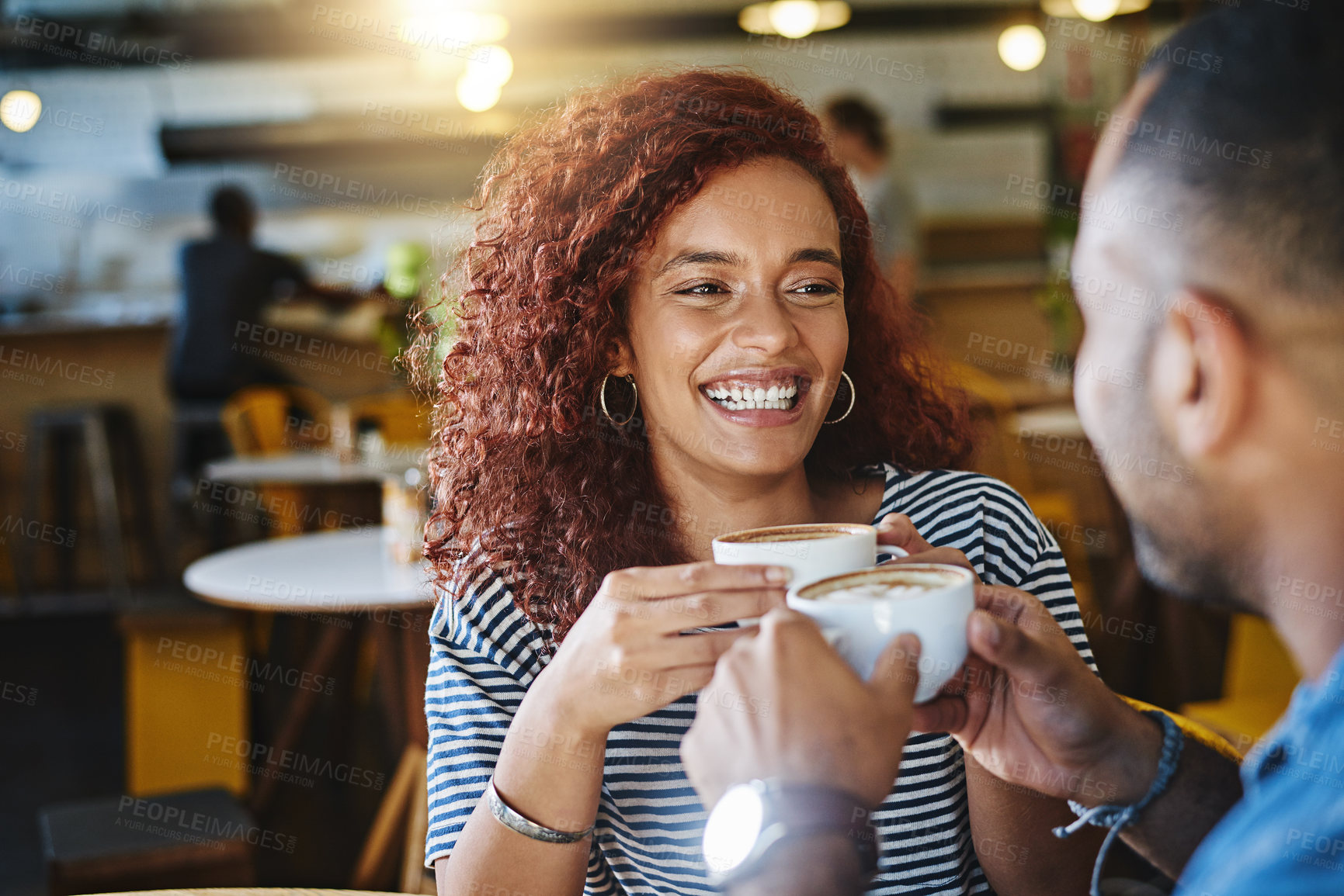 Buy stock photo Cropped shot of a happy young couple sitting together in a cafe and enjoy a coffee during a date