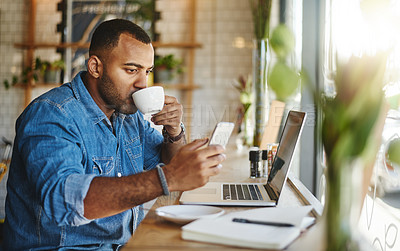 Buy stock photo Cropped shot of a handsome young businessman sitting in a cafe and drinking a cup of coffee while using technology