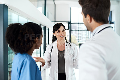 Buy stock photo Shot of a team of doctors having a discussion in a hospital