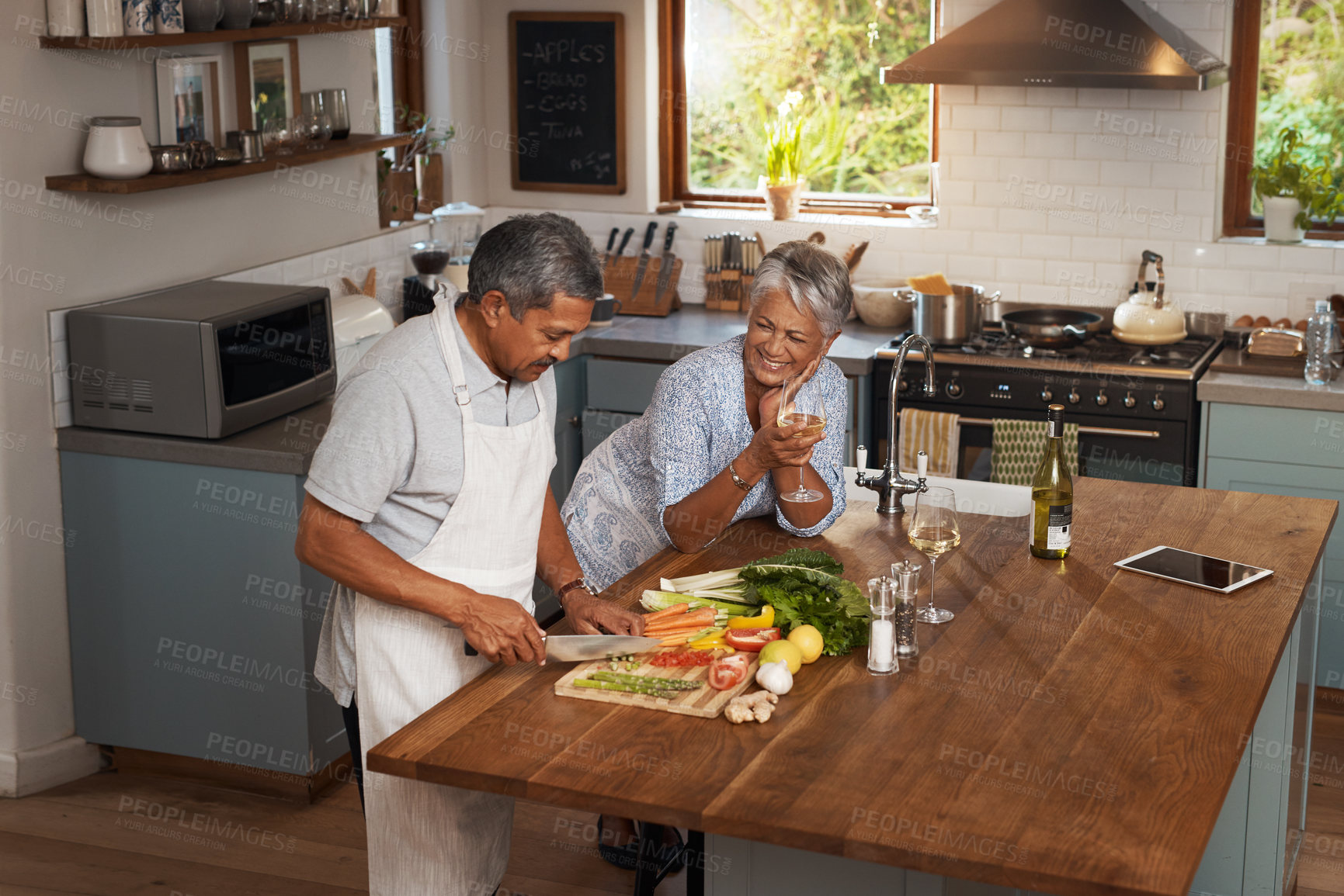Buy stock photo Happiness, cooking old man and woman with wine in kitchen, healthy food and bonding time together in home. Drink, glass and vegetables, senior couple with vegetable meal prep and diet in retirement.