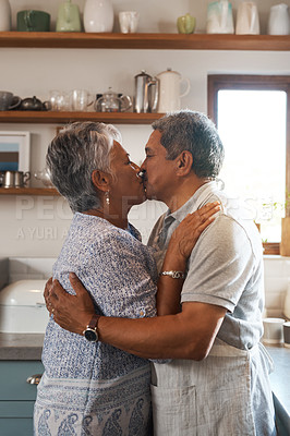 Buy stock photo Cropped shot of a mature couple kissing in the kitchen