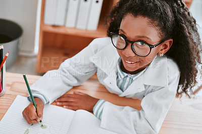 Buy stock photo Portrait of an adorable young school girl drawing a diagram in her exercise book in science class at school
