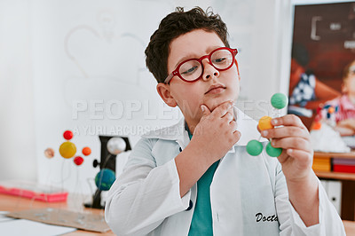 Buy stock photo Shot of an adorable young school boy learning about molecules in science class at school