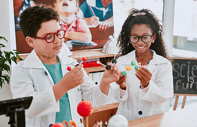 Buy stock photo Shot of an two adorable young school children learning about molecules in science class at school