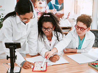 Buy stock photo Shot of a young science teacher giving a lesson to her pupils in a classroom at school