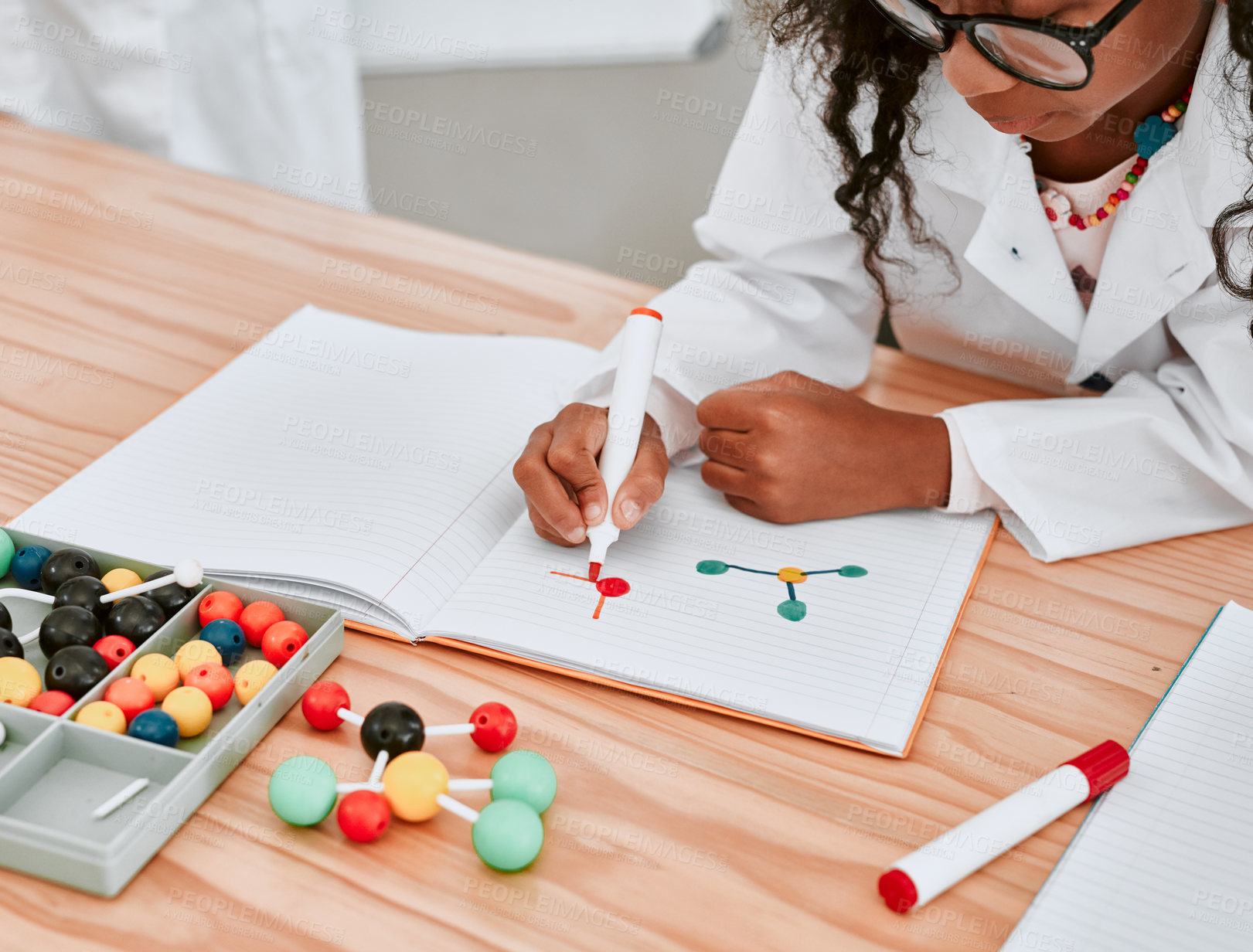 Buy stock photo Cropped shot of an adorable young school girl drawing a diagram in her exercise book in science class at school