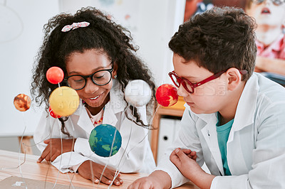 Buy stock photo Shot of two adorable young school pupils learning about planets and the solar system in science class at school