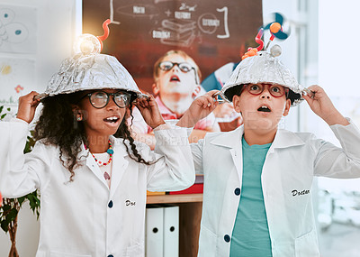 Buy stock photo Shot of two adorable young school pupils doing an experiment about electricity and light in science class at school