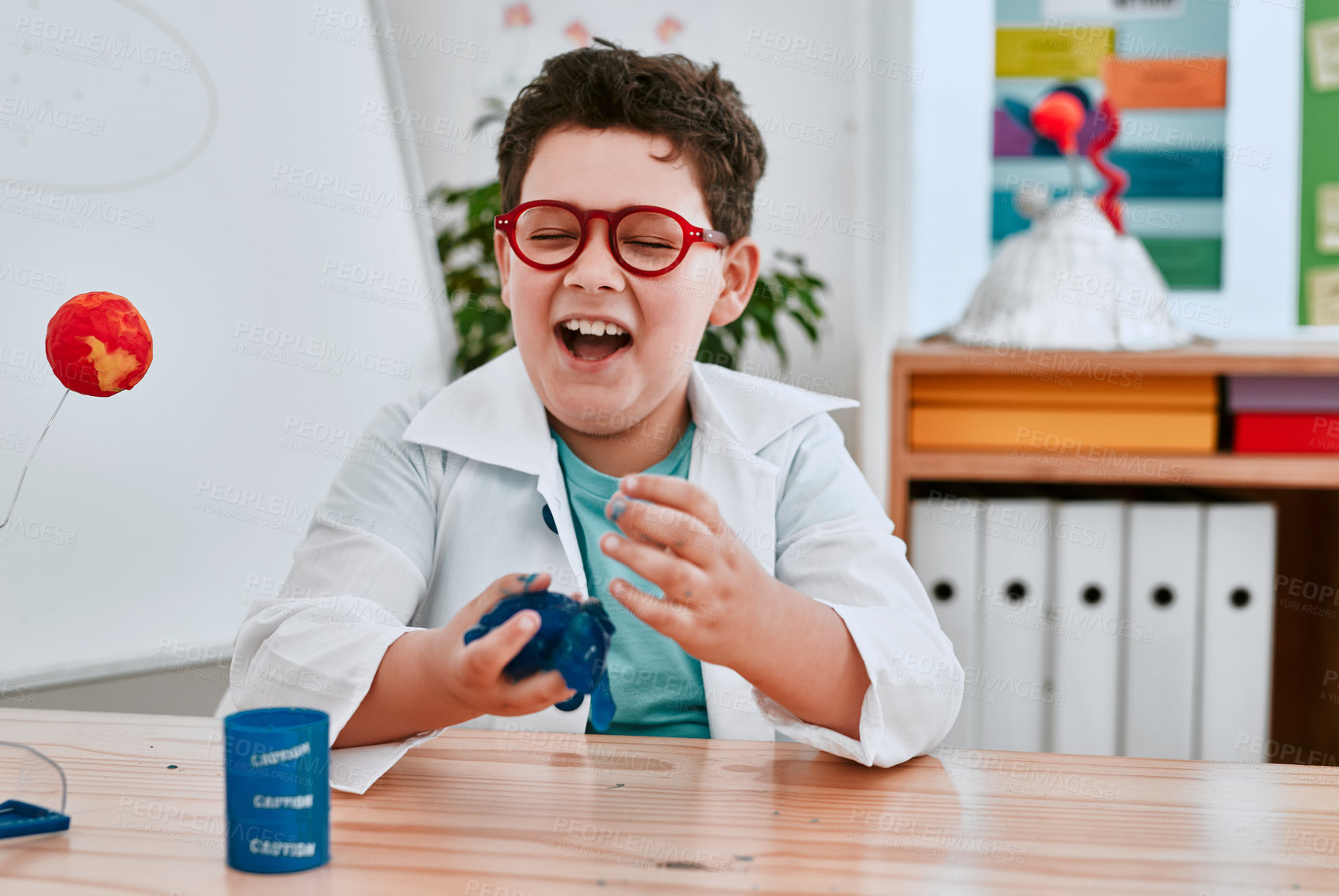 Buy stock photo Boy, learning and slime in classroom for science, thinking and lab coat with container at school. Child, blue liquid and education for chemical with ideas for studying, excited and laugh at academy