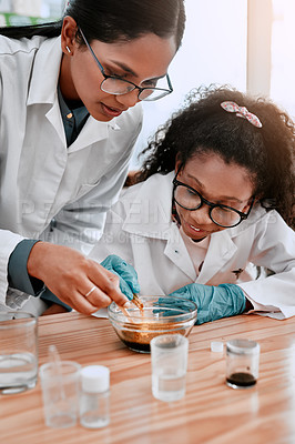 Buy stock photo Shot of an adorable young school girl doing an experiment with her science teacher at school