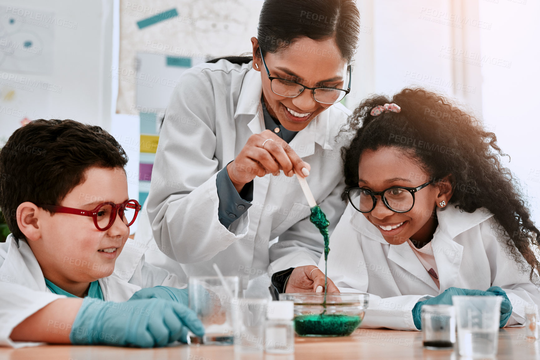 Buy stock photo Shot of two adorable young school pupils experimenting and making slime with their science teacher at school
