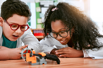 Buy stock photo Engineering, school and kids building a robot hand together in a classroom at school and being curious. Clever, education and young engineer students working in a science class doing research