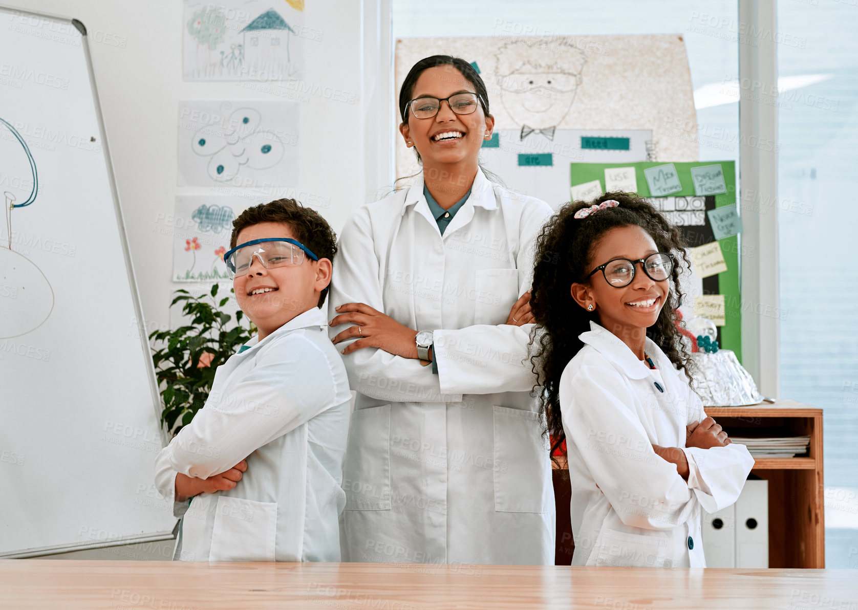 Buy stock photo Portrait of a confident little boy and girl standing together with their teacher in science class at school