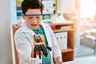 Buy stock photo Shot of an adorable little boy building a robot in science class at school
