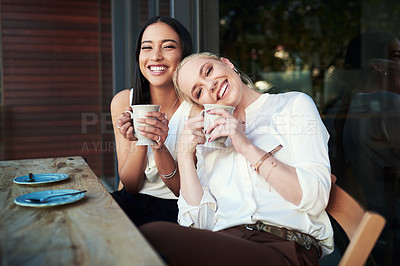 Buy stock photo Cropped shot of two young woman enjoying each other's company while having coffee at a cafe