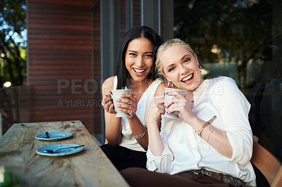 Buy stock photo Cropped shot of two young woman enjoying each other's company while having coffee at a cafe