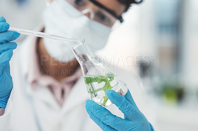 Buy stock photo Cropped shot of an unrecognizable female scientist dropping a liquid sample into a beaker containing a plant while working in a laboratory
