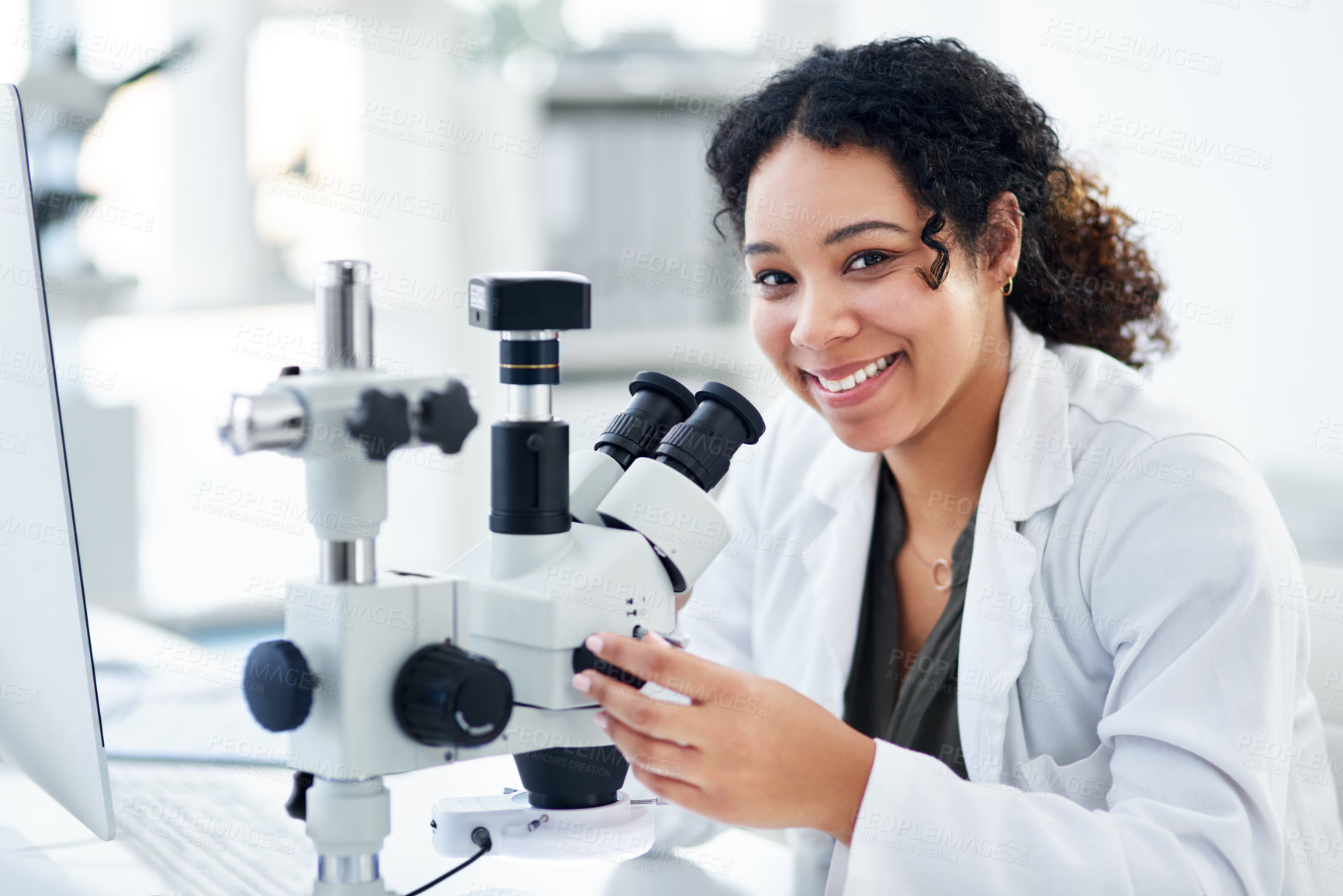 Buy stock photo Cropped shot of a young female scientist using a microscope in a laboratory