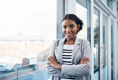 Buy stock photo Happy, confident and professional young business woman folding her arms while standing in a modern office. Portrait of a black woman leader smiling, looking proud, powerful, ready and focused 