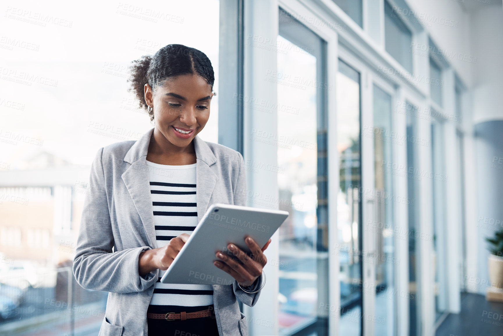 Buy stock photo One young corporate intern worker browsing on wireless technology. Smiling businesswoman working on a tablet, reading email message online or checking company SEO website data in modern office.