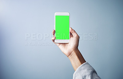 Buy stock photo Person, hand and phone with green screen for advertising or marketing on a gray studio background. Closeup of user with mobile smartphone display, chromakey or mockup space for app or interaction