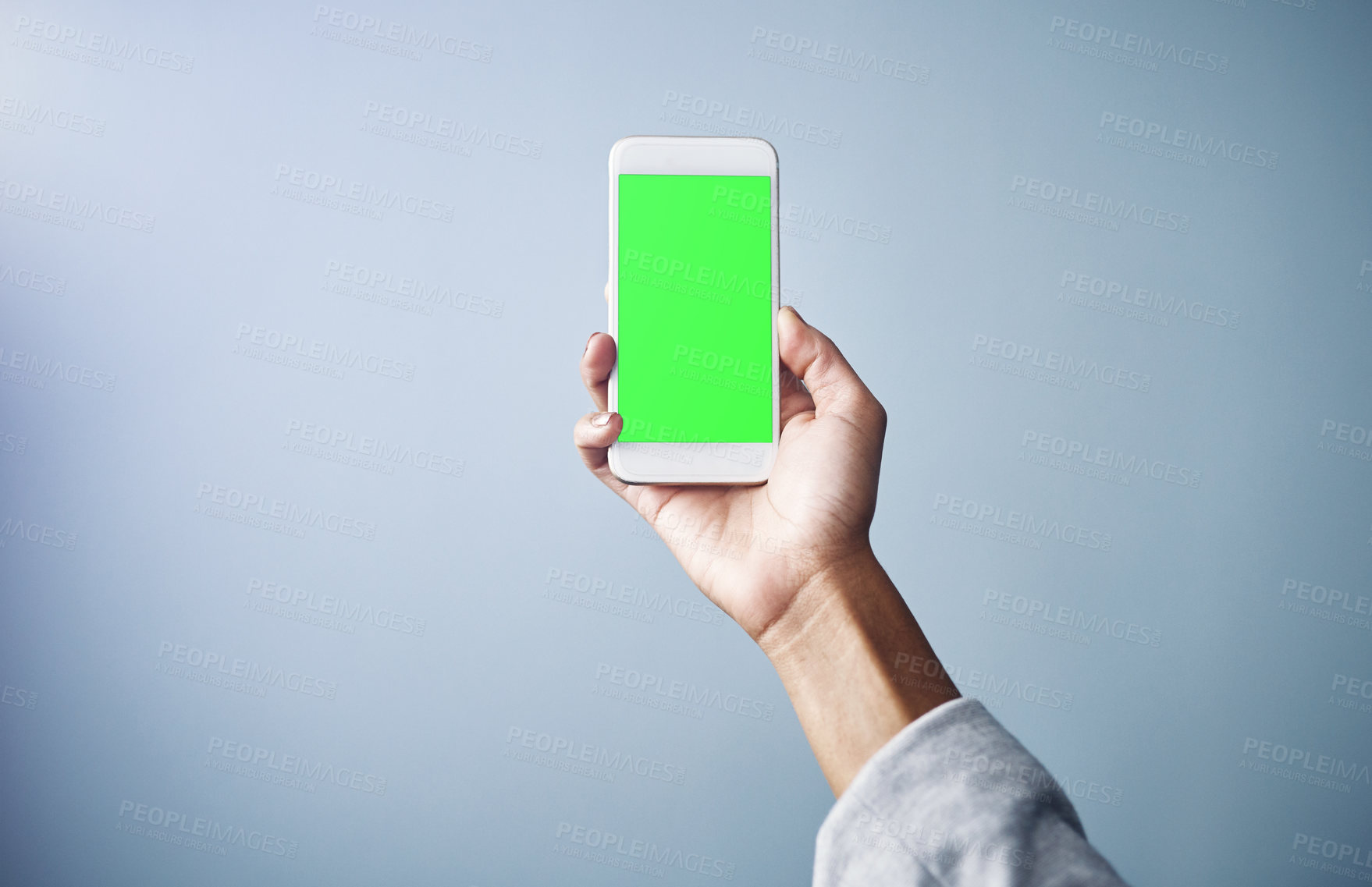 Buy stock photo Person, hand and phone with green screen for advertising or marketing on a gray studio background. Closeup of user with mobile smartphone display, chromakey or mockup space for app or interaction