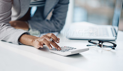 Buy stock photo Cropped shot of a businesswoman using a calculator at her desk in a modern office