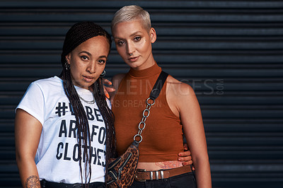 Buy stock photo Cropped portrait of two attractive young girlfriends standing together against a dark background