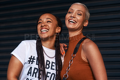 Buy stock photo Cropped shot of two attractive young girlfriends smiling while standing together against a dark background