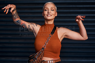 Buy stock photo Cropped shot of an attractive young woman standing with her arms raised against a dark background