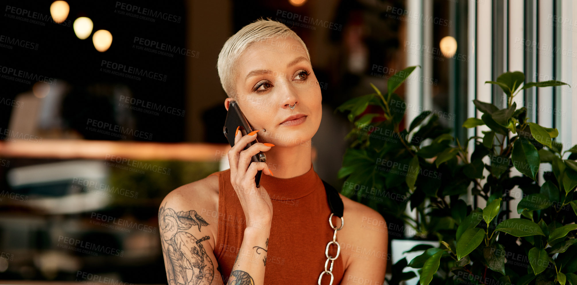Buy stock photo Shot of a young woman using her cellphone while sitting at a sidewalk cafe
