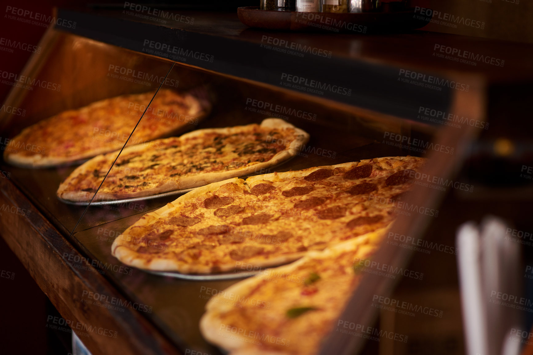 Buy stock photo Closeup shot of pizza on display in a cafe
