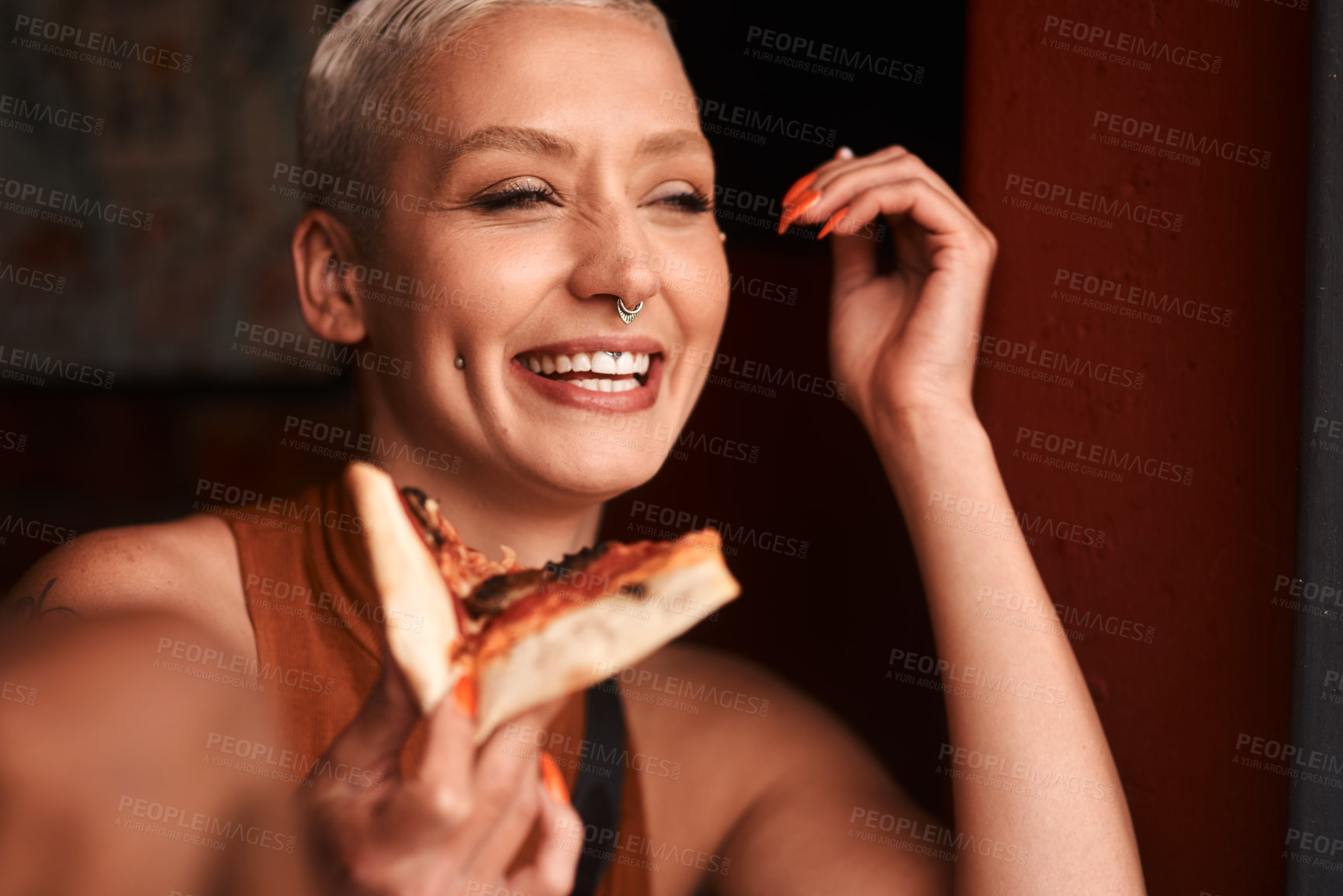 Buy stock photo Cropped shot of a young woman enjoying a slice of pizza in a cafe